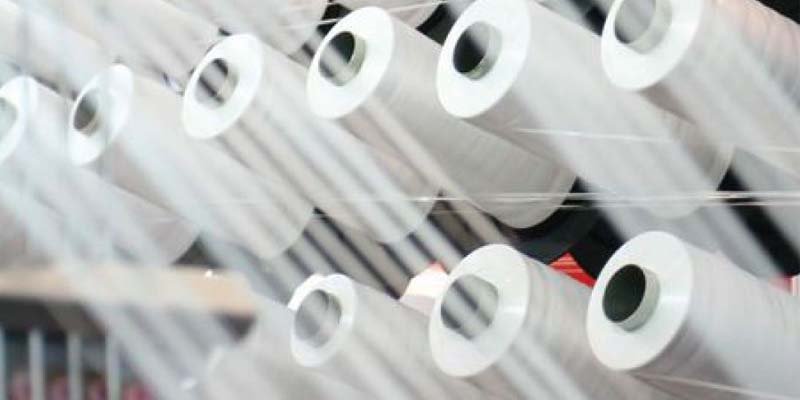 A detailed macro shot showing fiber sliver moving smoothly over a perforated surface.