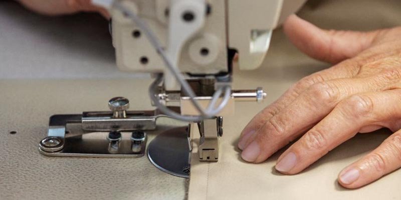 A spool of polyester thread next to a piece of cotton fabric