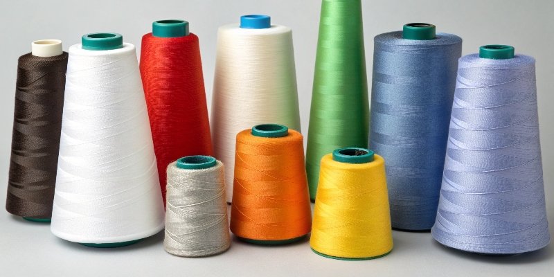 A variety of polyester thread spools in different colors and sizes